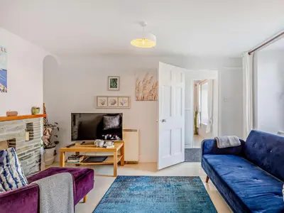 a living room with a blue couch and a fireplace at 3 Bed in Polruan oc-83821 in Fowey