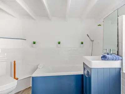 a bathroom with a blue and white sink and a toilet at 3 Bed in Polruan oc-83821 in Fowey