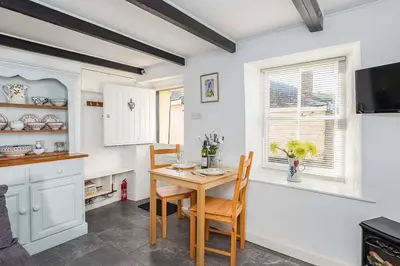 a kitchen with a table and chairs and a window at Homestead in Port Isaac