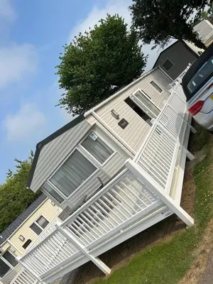 a house with a porch on the side of it at CaravanSleeps4-Beachfront-Garden-Patio in Newquay