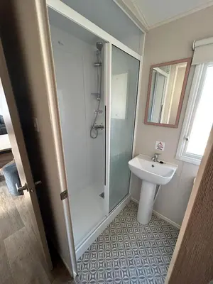 a bathroom with a shower and a sink at CaravanSleeps4-Beachfront-Garden-Patio in Newquay