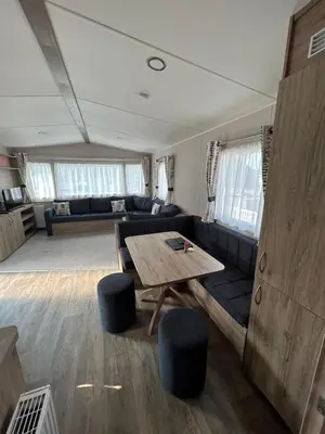 a living room with a couch and a table at CaravanSleeps4-Beachfront-Garden-Patio in Newquay