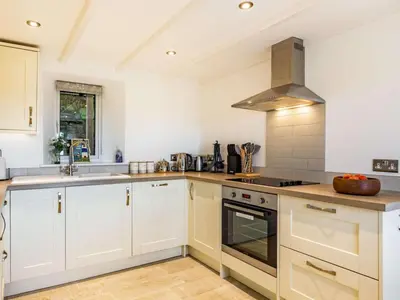 a kitchen with white cabinets and a stove top oven at 2 Bed in Fowey oc-86873 in Saint Veep