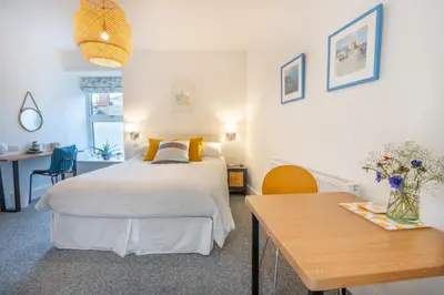 a bedroom with a bed and a desk and a table at Porthleven B and B in Helston