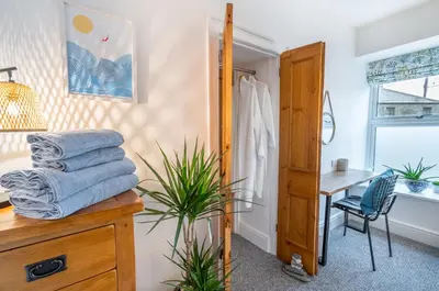 a bathroom with a sink and a desk and a mirror at Porthleven B and B in Helston