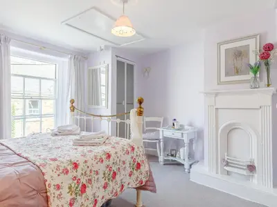 a white bedroom with a bed and a fireplace at 3 Bed in Polruan oc-pc012 in Polruan