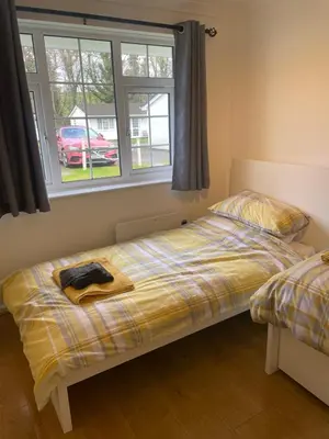 a bedroom with a bed and a window at BumbleBee Lodge in Saint Cleer