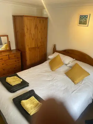 a bedroom with a bed with two towels on it at BumbleBee Lodge in Saint Cleer