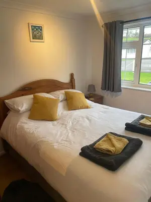 a bedroom with a bed with two towels on it at BumbleBee Lodge in Saint Cleer