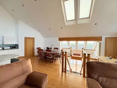 a living room with a table and a dining room at Caledonian House - Newquay in Newquay