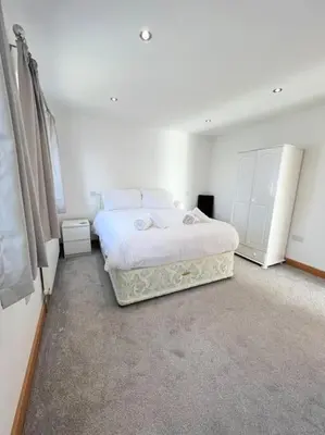 a bedroom with a white bed in a room at Caledonian House - Newquay in Newquay