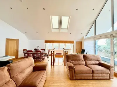 a living room with a couch and a dining room at Caledonian House - Newquay in Newquay