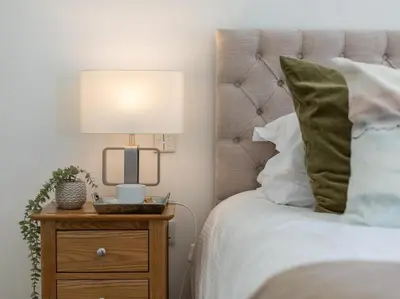 a bedroom with a bed with a lamp on a night stand at 3 Bed in South Tehidy oc-90549 in Camborne