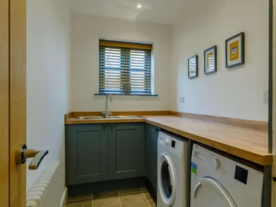a kitchen with a sink and a washing machine at 4 Bed in Helston oc-90391 in Crowan