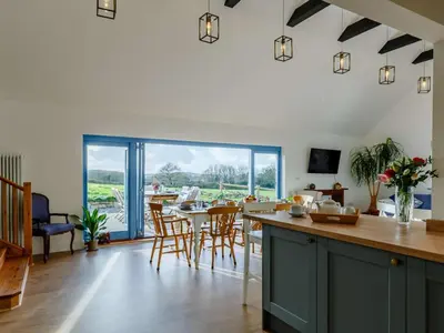 a kitchen with a table and chairs and a large window at 4 Bed in Helston oc-90391 in Crowan
