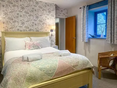 a bedroom with a bed with a floral wallpaper at 4 Bed in Helston oc-90391 in Crowan