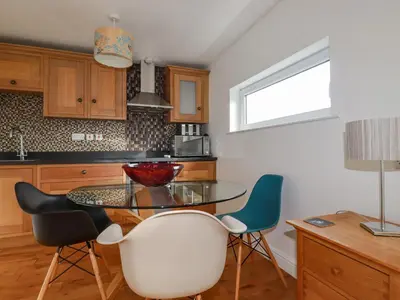 a kitchen with a glass table and two chairs at Lapwing in Perranporth