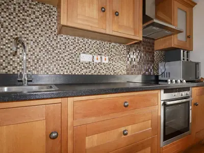 a kitchen with wooden cabinets and a sink at Lapwing in Perranporth