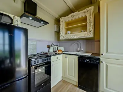 a kitchen with a stove and a black refrigerator at 1 Bed in Camelford oc-90818 in Camelford