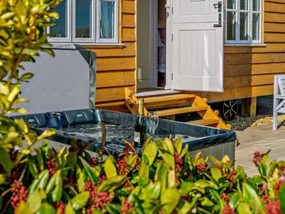 a hot tub in a yard next to a house at 1 Bed in Camelford oc-90818 in Camelford