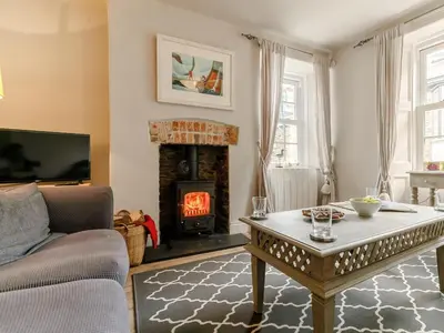 a living room with a fireplace and a coffee table at 2 Bed in Fowey oc-91396 in Fowey
