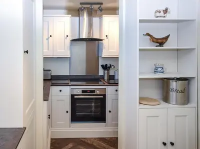 a kitchen with white cabinets and a stove at 2 Bed in Fowey oc-91396 in Fowey