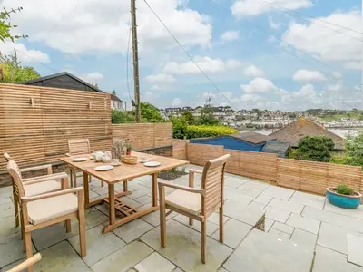 a patio with a wooden table and chairs on a balcony at 2 Bed in Fowey oc-91396 in Fowey