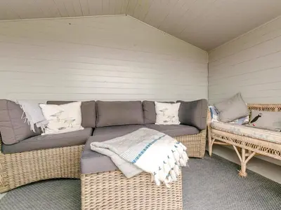 a porch with a couch and two wicker benches at 2 Bed in Fowey oc-91396 in Fowey