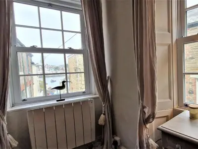 a window with a bird sitting on a window sill at 2 Bed in Fowey oc-91396 in Fowey