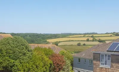 a view of a house with solar panels on the roof at Modern open plan house, sea views and hot tub in Falmouth