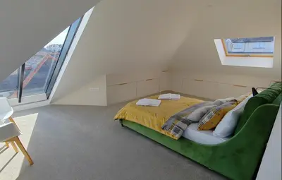 a bedroom with a bed and a green couch at Modern open plan house, sea views and hot tub in Falmouth