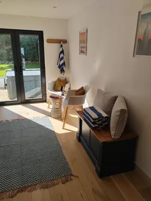 a living room with a couch and a table at Modern open plan house, sea views and hot tub in Falmouth