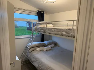 a bunk bed in a small room with a window at Padstow Lodge in Padstow