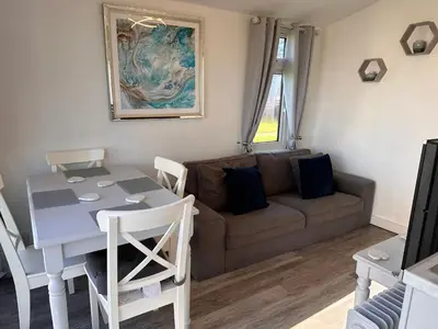 a living room with a table and a couch at Padstow Lodge in Padstow