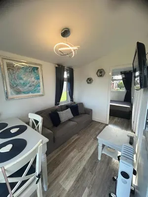 a living room with a couch and a table at Padstow Lodge in Padstow