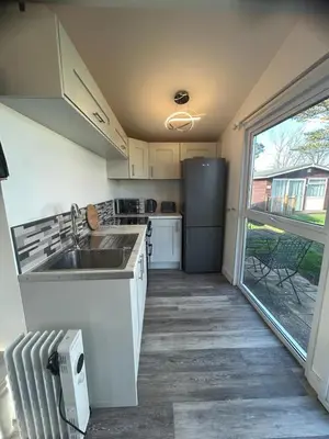 a kitchen with a sink and a refrigerator at Padstow Lodge in Padstow