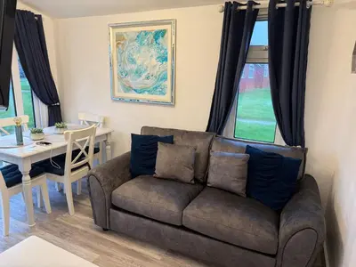 a living room with a couch and a table at Padstow Lodge in Padstow
