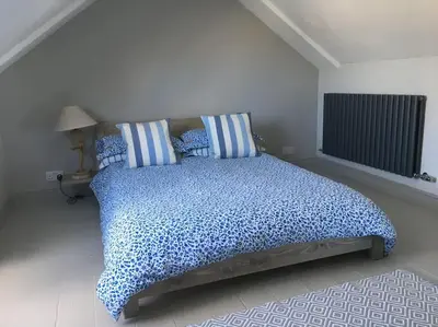a bedroom with a large bed with blue pillows at Sea Breeze - 3 Bed House, Parking for 2 Cars in St Ives