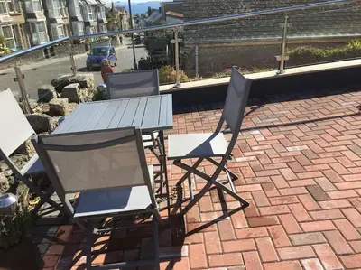 two chairs and a table on a brick patio at Sea Breeze - 3 Bed House, Parking for 2 Cars in St Ives