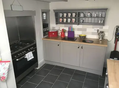 a kitchen with white cabinets and a black oven at Sea Breeze - 3 Bed House, Parking for 2 Cars in St Ives