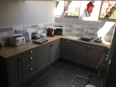 a kitchen with gray cabinets and a counter top with a sink at Sea Breeze - 3 Bed House, Parking for 2 Cars in St Ives