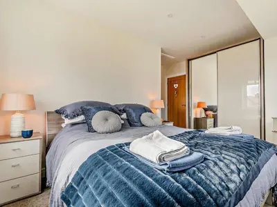 a bedroom with a large bed with blue pillows at 4 Bed in Fowey oc-91931 in Fowey