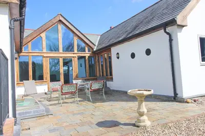 a house with a patio with chairs and a table at Beachside holiday home in St Merryn