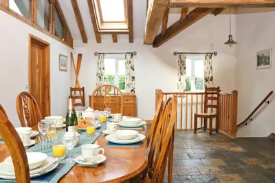 a dining room with a wooden table and chairs at Beachside holiday home in St Merryn
