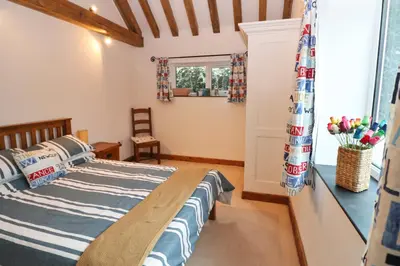 a bedroom with a bed and a window at Beachside holiday home in St Merryn
