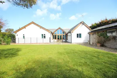 a house with a lawn in front of it at Beachside holiday home in St Merryn