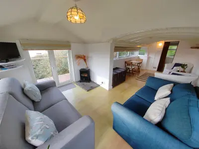 a living room with a blue couch and a table at Unique coastal detached property in Truro