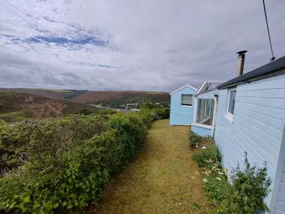 a blue house with a yard next to it at Unique coastal detached property in Truro