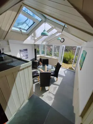 an open kitchen and living room with a vaulted ceiling at Unique coastal detached property in Truro