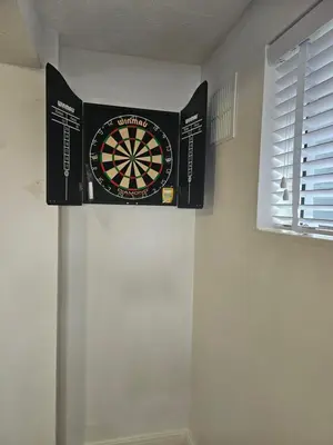a dartboard hanging on a wall in a room at Stunning Front Line Ocean Views Luxury Beach House in Downderry